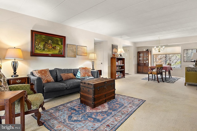 carpeted living room with a notable chandelier