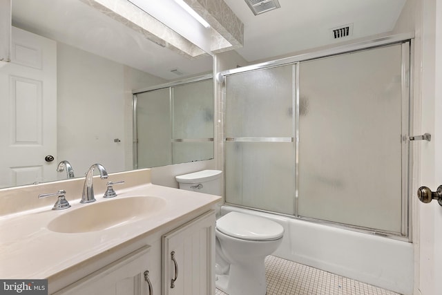 full bathroom with tile patterned floors, vanity, toilet, and bath / shower combo with glass door