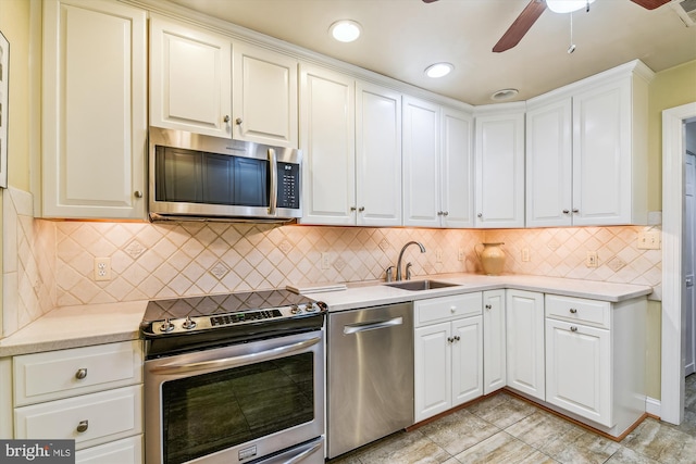 kitchen featuring white cabinets, stainless steel appliances, tasteful backsplash, and sink