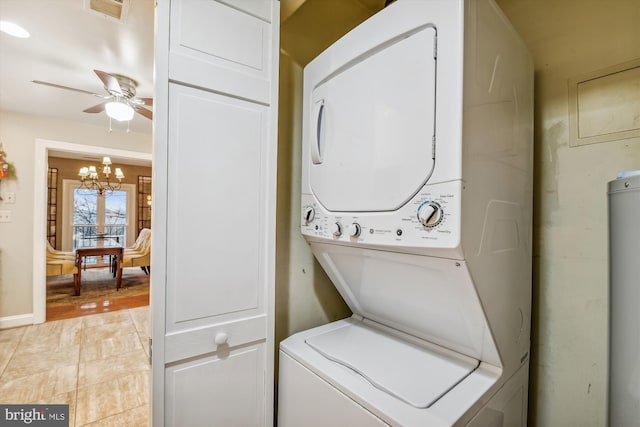 clothes washing area with ceiling fan with notable chandelier, light hardwood / wood-style floors, and stacked washer / dryer