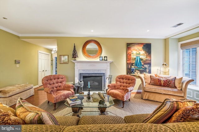 living room featuring a high end fireplace, wood-type flooring, and ornamental molding