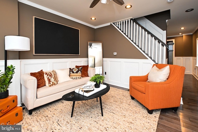 living room featuring dark hardwood / wood-style flooring, ceiling fan, and ornamental molding