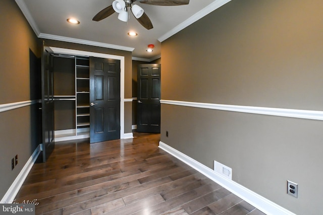 unfurnished bedroom with dark hardwood / wood-style floors, ceiling fan, ornamental molding, and a closet