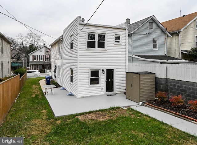 rear view of house with a yard and a shed