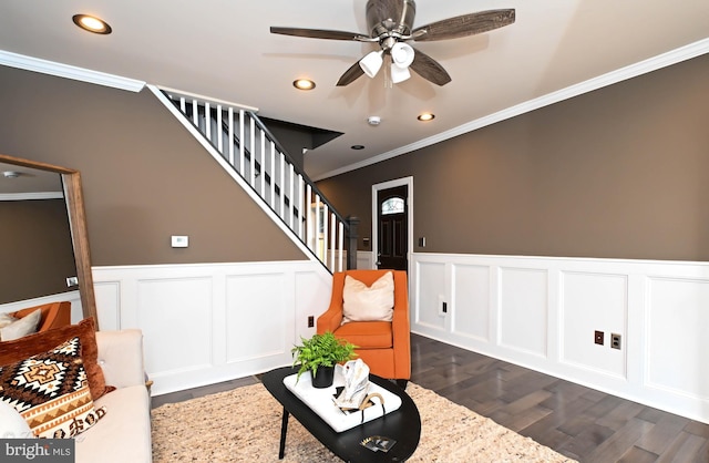 sitting room with dark hardwood / wood-style floors, ceiling fan, and ornamental molding