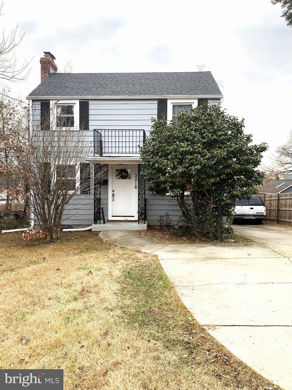 front of property with a balcony and a front lawn