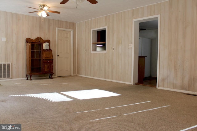 carpeted empty room featuring ceiling fan