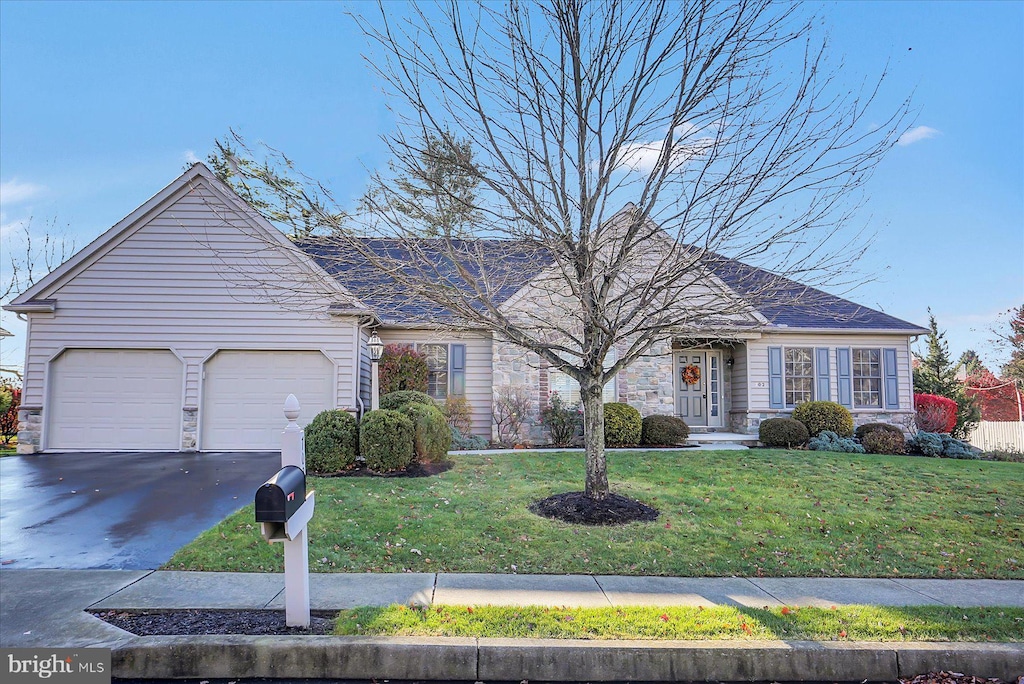 ranch-style house featuring a front lawn and a garage