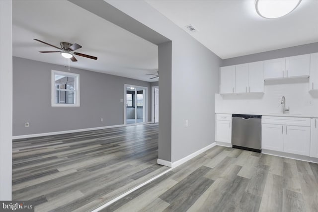 kitchen featuring white cabinets, light wood-type flooring, and stainless steel dishwasher