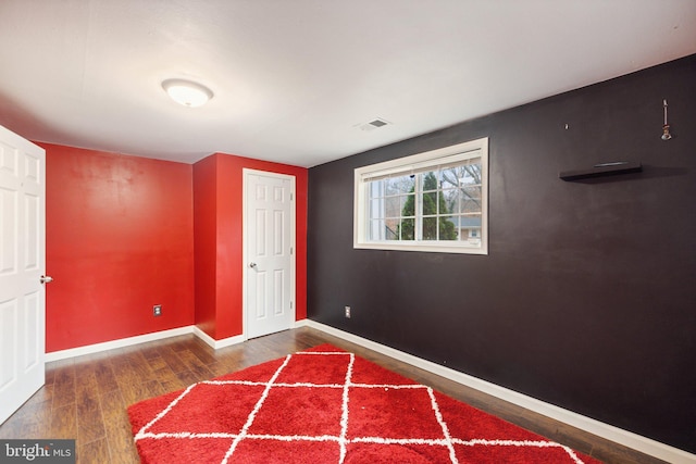 unfurnished bedroom with dark hardwood / wood-style flooring