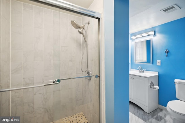 bathroom with vanity, a shower with shower door, and toilet