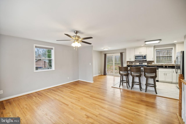 interior space with ceiling fan, light hardwood / wood-style floors, and a wealth of natural light