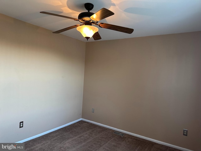 unfurnished room with dark colored carpet and ceiling fan