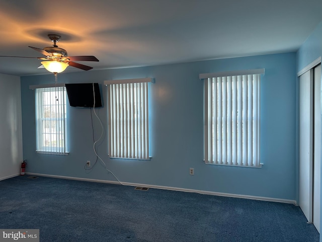 unfurnished room with ceiling fan and carpet floors