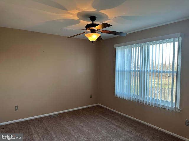 spare room with ceiling fan, carpet floors, and a wealth of natural light