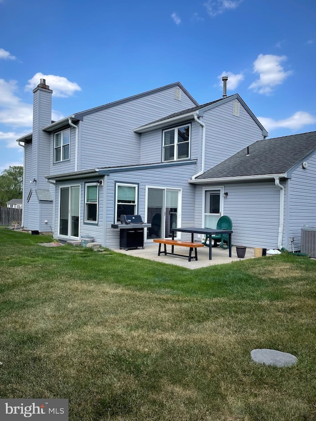 rear view of property featuring a lawn, a patio, and central AC unit