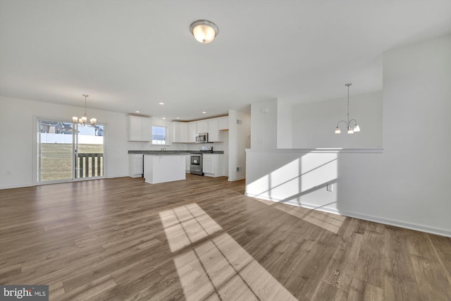 unfurnished living room featuring hardwood / wood-style flooring and a notable chandelier