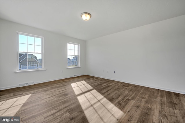 unfurnished room with hardwood / wood-style flooring