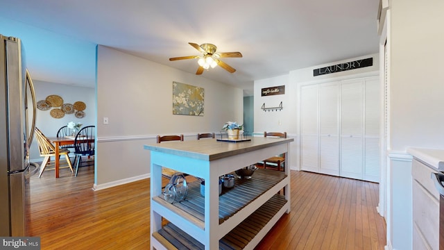 kitchen with hardwood / wood-style floors, ceiling fan, and stainless steel fridge