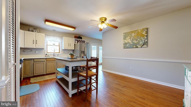 kitchen featuring stainless steel fridge with ice dispenser, ceiling fan, sink, and hardwood / wood-style flooring