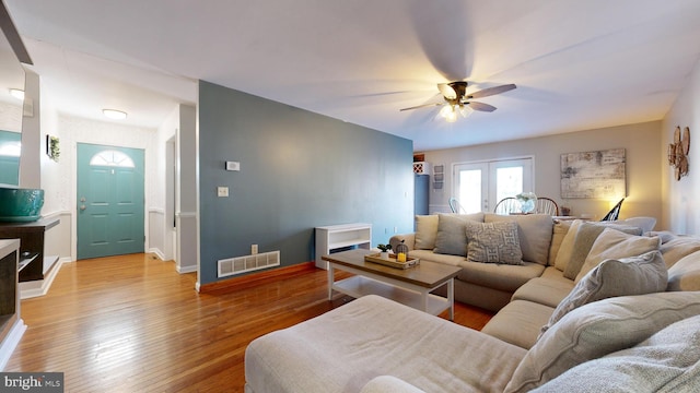 living room featuring ceiling fan, light hardwood / wood-style flooring, and french doors