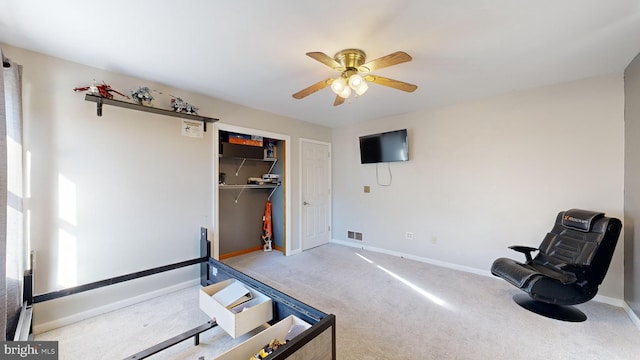 living area with carpet flooring and ceiling fan