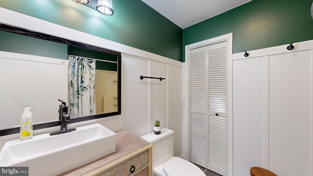 bathroom with a shower with shower curtain, vanity, and toilet