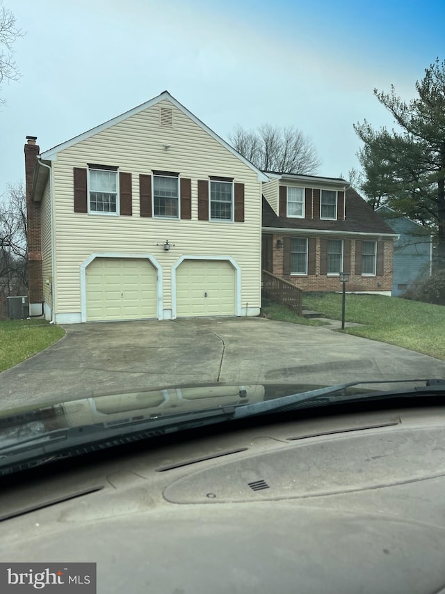 view of front of property with a garage and central air condition unit