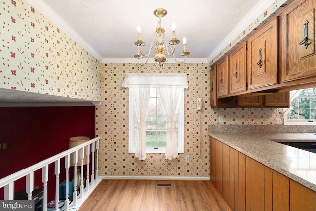 kitchen featuring light hardwood / wood-style floors, crown molding, and an inviting chandelier