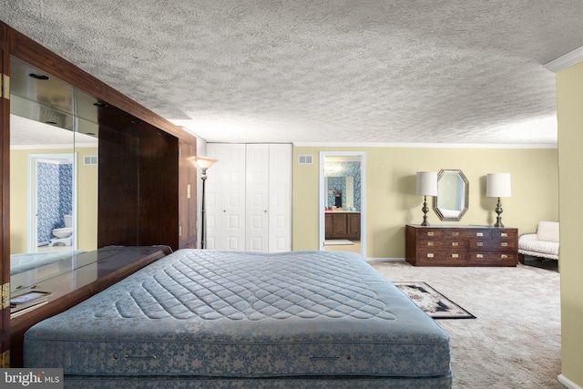 bedroom with a textured ceiling, connected bathroom, light colored carpet, and crown molding