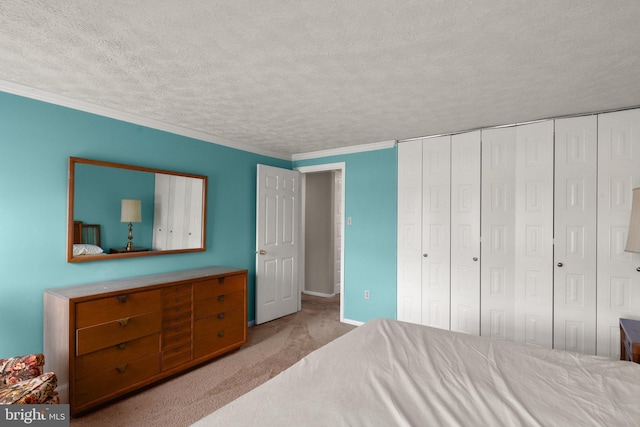 carpeted bedroom with crown molding, a closet, and a textured ceiling