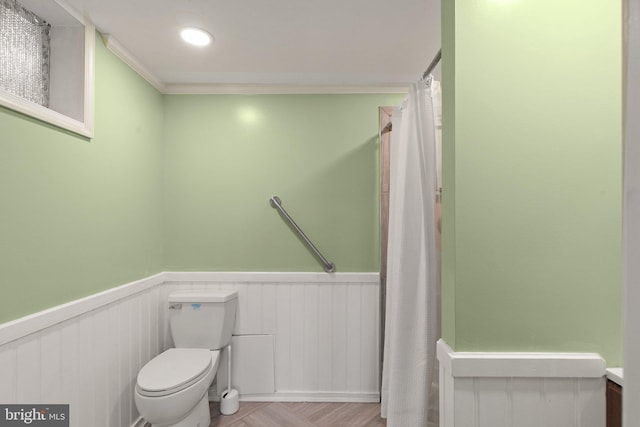 bathroom with ornamental molding and toilet