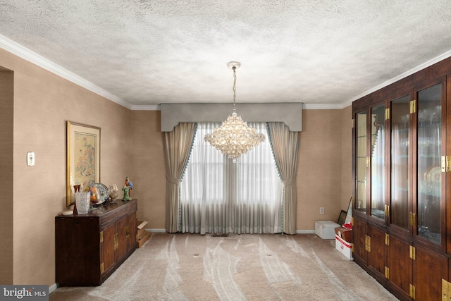 entryway with light colored carpet, ornamental molding, a textured ceiling, and a notable chandelier