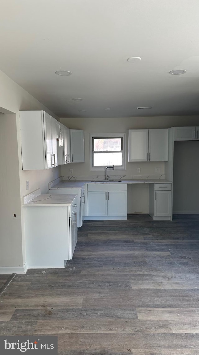 kitchen featuring white cabinets and dark hardwood / wood-style flooring