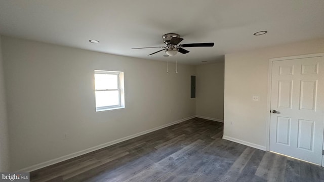 empty room with electric panel, ceiling fan, and dark wood-type flooring