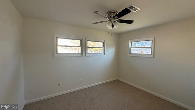 spare room featuring a wealth of natural light, carpet, and ceiling fan