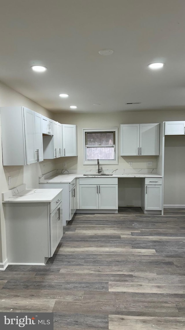 kitchen featuring dark hardwood / wood-style floors, white cabinetry, and sink