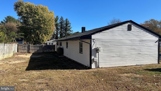 view of side of home with a yard