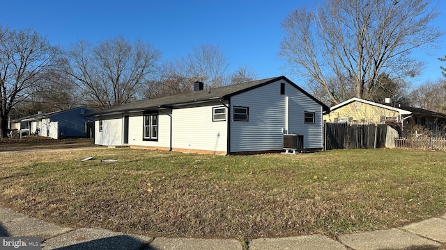 exterior space with central AC unit and a lawn