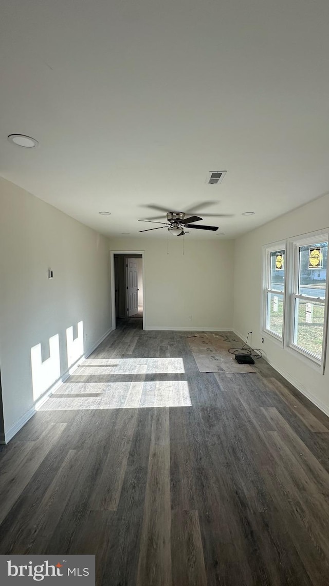 empty room featuring ceiling fan and dark hardwood / wood-style flooring