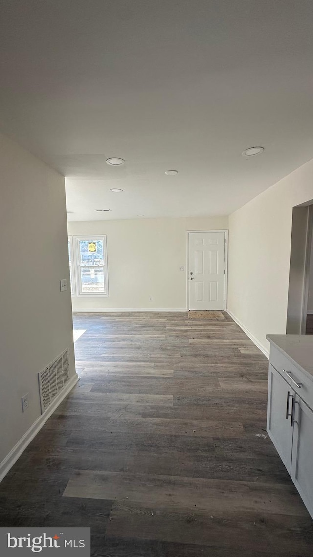 unfurnished room with dark wood-type flooring