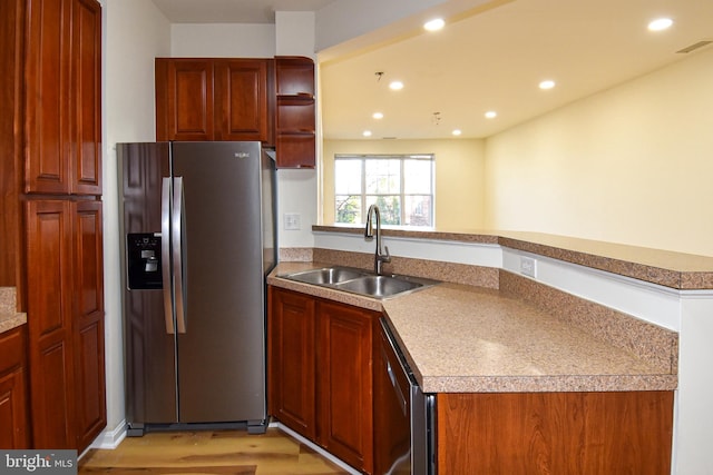 kitchen featuring sink, dishwasher, stainless steel fridge with ice dispenser, kitchen peninsula, and light wood-type flooring