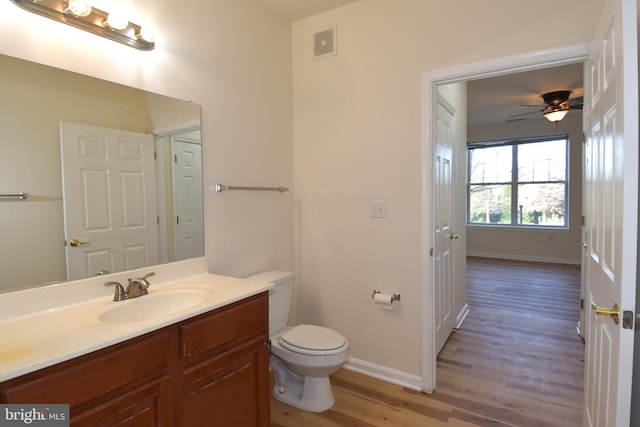 bathroom featuring hardwood / wood-style floors, vanity, toilet, and ceiling fan