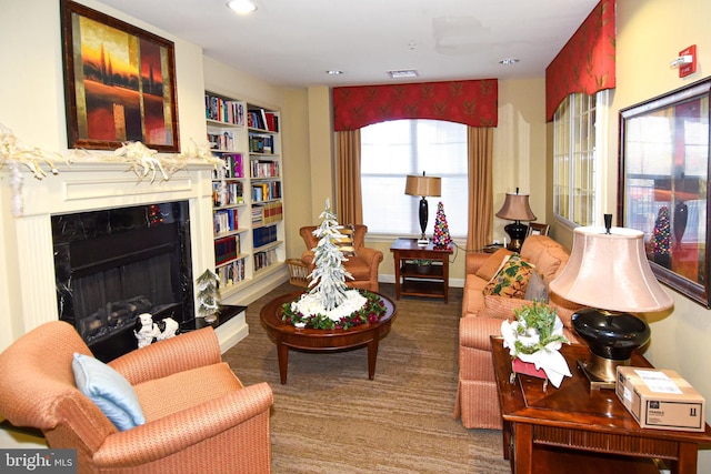 living room featuring built in shelves and a fireplace