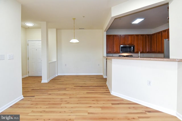 kitchen with pendant lighting and light hardwood / wood-style floors