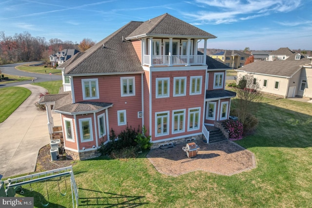 rear view of property with a yard and a balcony