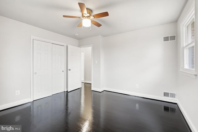 unfurnished bedroom with ceiling fan and a closet