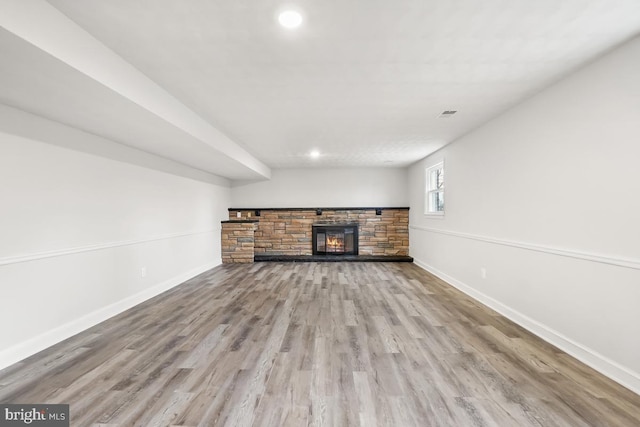 unfurnished living room with a fireplace and light wood-type flooring