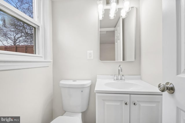 bathroom with a wealth of natural light, vanity, and toilet