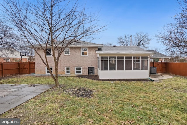 rear view of property featuring central air condition unit, a lawn, and a sunroom